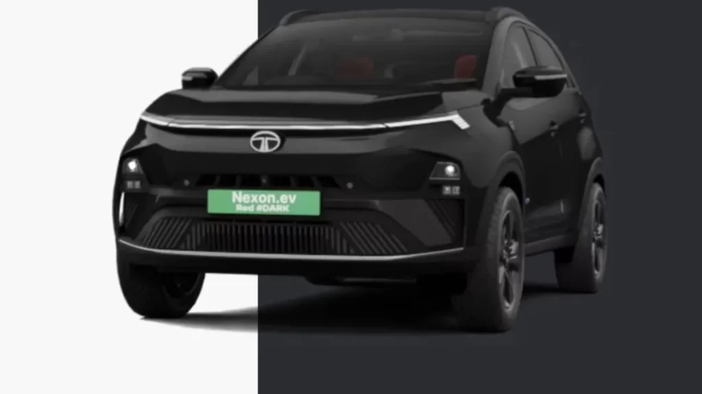 A front-facing shot of the all-black Tata Nexon.ev Red #DARK edition electric SUV, with a white and black split background to highlight its dark color scheme. The red accents are visible on the interior seats.