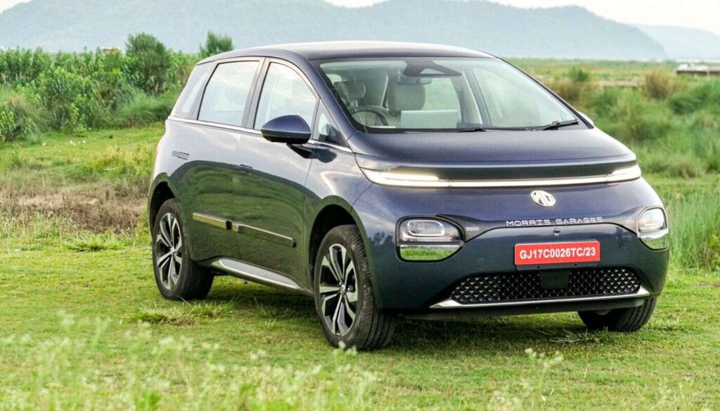 घास के मैदान में खड़ी नीली MG Windsor EV – भारत में बढ़ती Electric Car Sales में योगदान देने वाला एक कॉम्पैक्ट मॉडल।