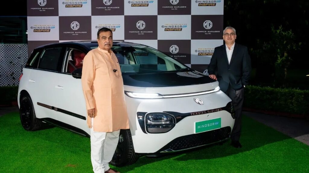 केंद्रीय मंत्री नितिन गडकरी और एक एमजी अधिकारी MG Windsor Inspire Edition के लॉन्च इवेंट में नई EV के साथ पोज देते हुए।