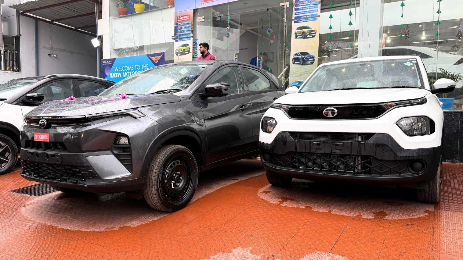 एक डीलरशिप पर खड़ी Tata Nexon (ग्रे) और Tata Punch (सफेद), ये दोनों मॉडल Tata Motors September Sales के मुख्य चालक रहे।
