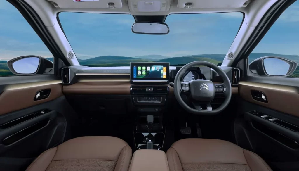 Deep Forest Green रंग की Citroen Aircross X SUV का फ्रंट व्यू, जो जंगल जैसे बैकग्राउंड में खड़ी है। यह कार New Citroen Aircross X Launch का हिस्सा है।