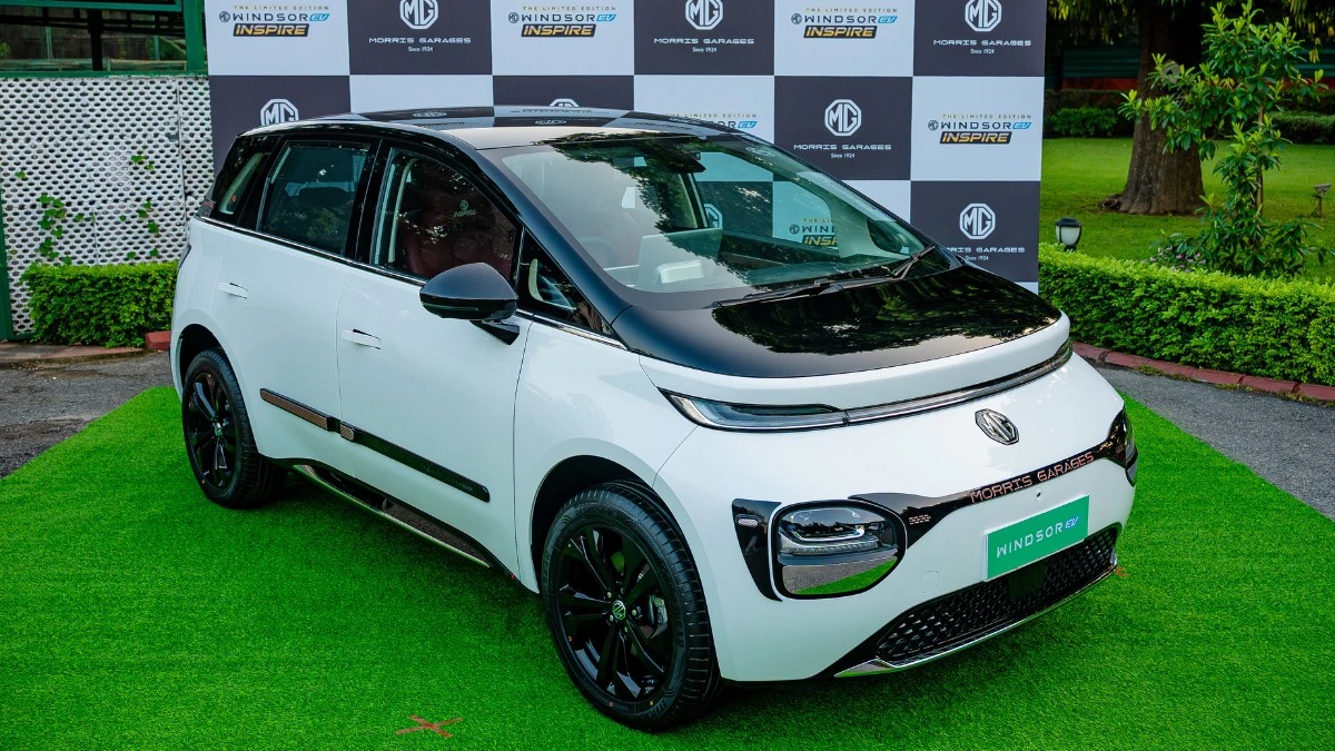 एक हरे लॉन पर खड़ी MG Windsor Inspire Edition, लॉन्च इवेंट के दौरान सफेद और काले डुअल-टोन में अपनी स्टाइलिश उपस्थिति दिखा रही है।