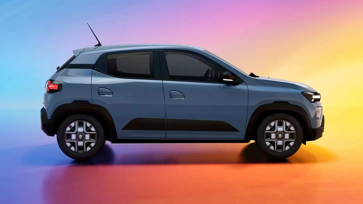 नीले वातावरण में Renault Kwid EV का फ्रंट-एंगल शॉट, जिसमें इसकी 10.1-इंच टचस्क्रीन वाली नई केबिन टेक्नोलॉजी और मॉडर्न सील्ड ग्रिल दिखती है। यह Kwid EV भारतीय बाज़ार के लिए एक महत्वपूर्ण इलेक्ट्रिक हैचबैक है।